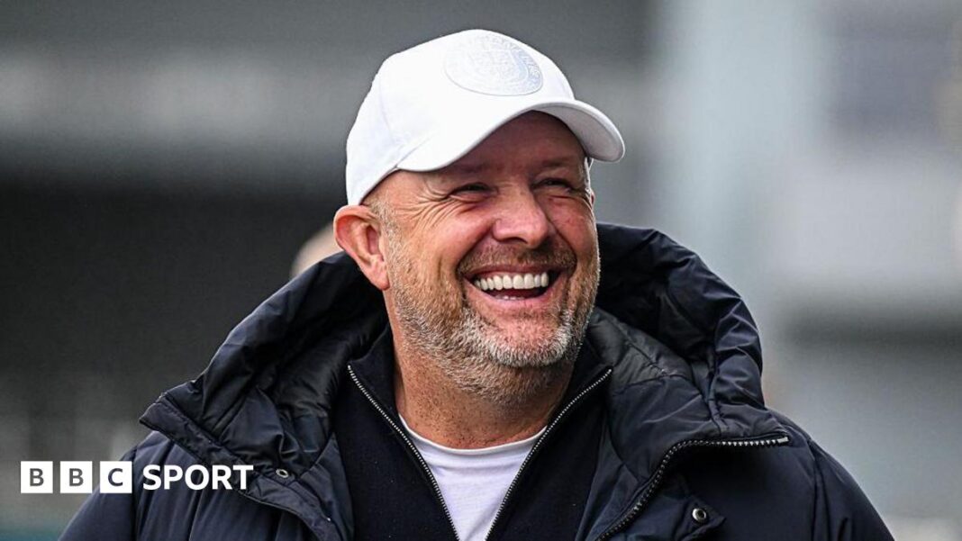 Andy Woodman: Šef Bromleya se natječe da završi ‘Projekt Šampiona’ u Ligi 2 Andy Woodman, wearing a white cap and coat, laughs on the touchline