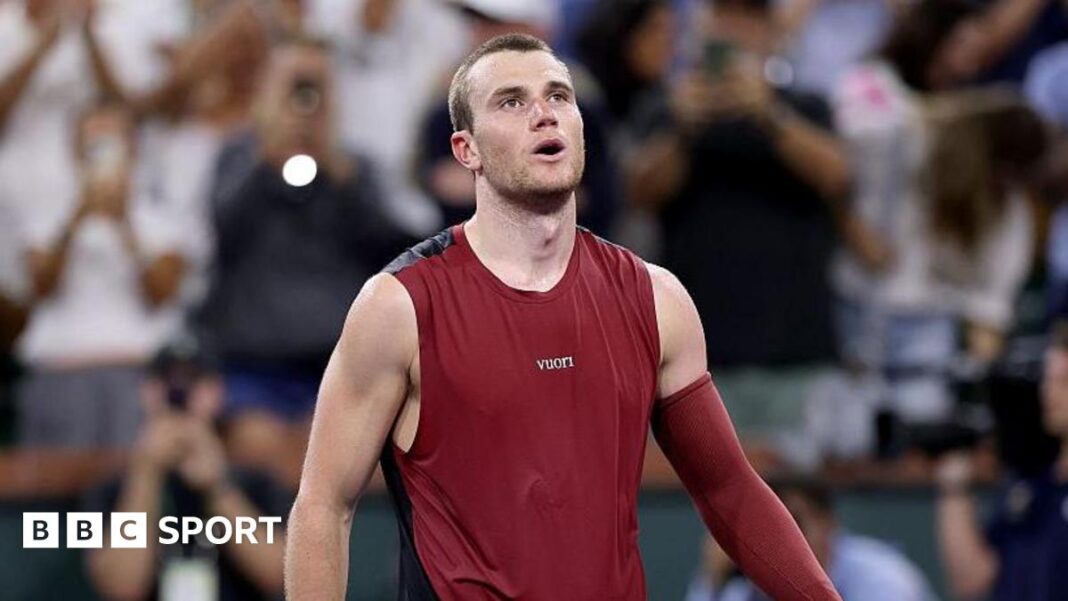 Jack Draper će propustiti turnire u Madridu i Rimu zbog povrede koljena Jack Draper, wearing a maroon vest with a maroon sleeve on his left arm, looks upwards with his mouth open