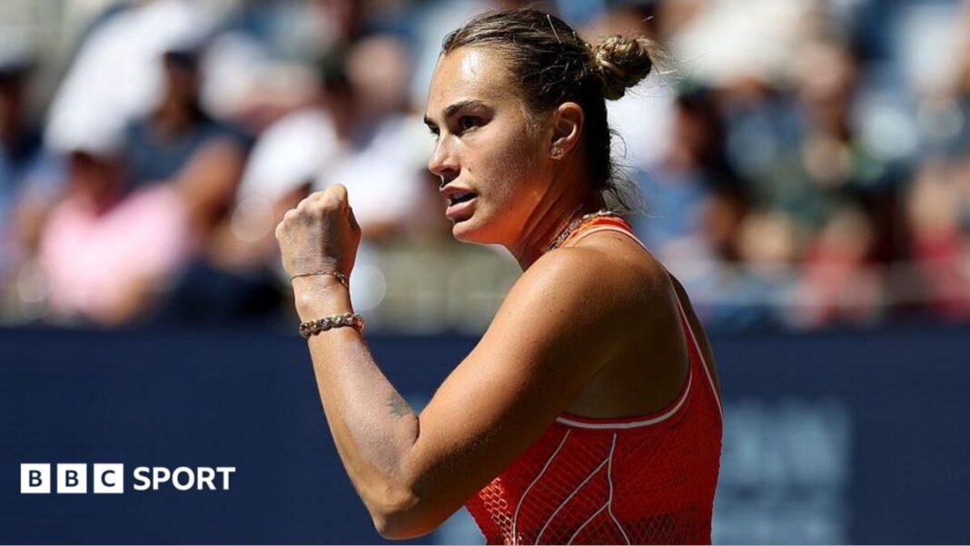 Rezultati US Opena 2026: Aryna Sabalenka uzvratila je Lindi Noskovoj kako bi održala odbranu titule u životu Aryna Sabalenka, wearing an orange sleeveless dress, stands side on and raises a clenched left fist